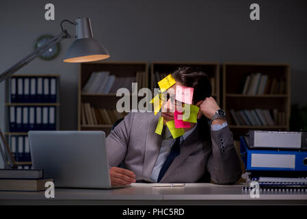 Uomo d'affari che soggiornano in ritardo per ordinare le priorità Foto Stock