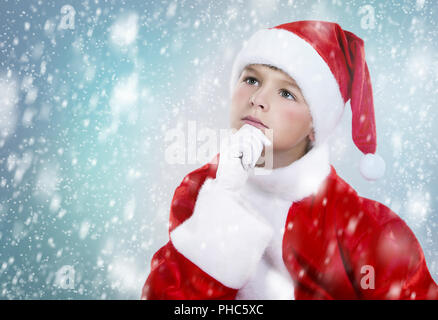 Ragazzo vestito come Santa nel paesaggio invernale Foto Stock