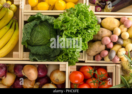 Vista aerea di separati rettangolare in legno Scatole di produrre casuale compreso le lattughe e le banane accanto a ciascun altro Foto Stock