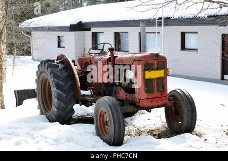 Il vecchio trattore rosso su una fattoria Foto Stock