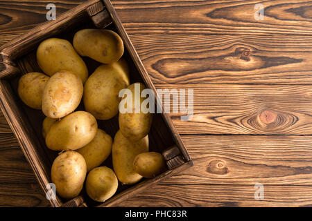 Le piccole casse di legno riempito di lava fresca sana patate organico sul display su un tavolo al mercato famers, visto dal di sopra con lo spazio di copia Foto Stock