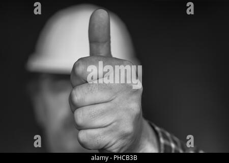 Lavoratore edile che mostra la mano con il pollice in alto Foto Stock