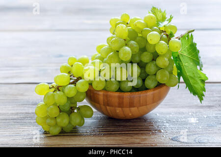 Grappolo di uva bianca in una ciotola di legno. Foto Stock