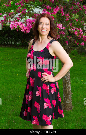 Donna sotto un albero ciliegio Foto Stock
