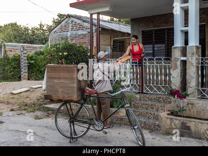 Un uomo vanno in bicicletta tutti attraverso il quartiere di offrire pane fresco ogni mattina in un piccolo sobborgo di Trinidad, Cuba. Foto Stock