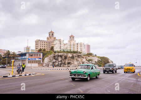 L'Avana, Cuba / Marzo 21, 2016: Malecon - seawall - autostrada nella parte anteriore del colle sormontato da uno storico Hotel Nacional de Cuba. Foto Stock