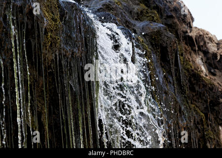 Dettaglio di acqua che fluisce attraverso una piccola cascata. Foto Stock