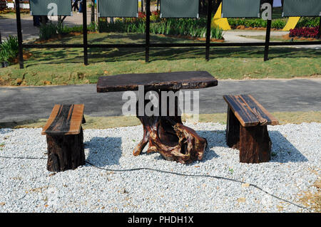 Tavoli e panche di legno di monconi e utilizzato il legno. Designer creatività rende bella e preziosa. Foto Stock