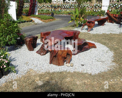 Tavoli e panche di legno di monconi e utilizzato il legno. Designer creatività rende bella e preziosa. Foto Stock