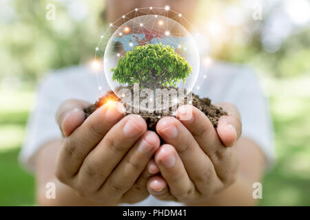 Salvare il mondo e il concetto di innovazione, ragazza con piccola pianta o albero alberello crescono dal suolo su Palm con linea di collegamento e guanto intorno a. Foto Stock