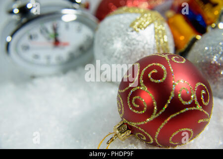 Anno nuovo orologio giacciono in Colorati luminosamente shiny tinsel Foto Stock