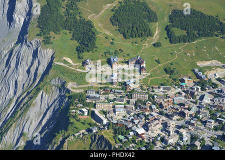 VISTA AEREA. Headward Erosion, troppo vicino per il comfort, al limite della città. Stazione sciistica di Les Deux Alpes in estate. Isère, Auvergne-Rhône-Alpes, Francia Foto Stock