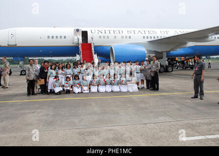 Gli studenti e gli insegnanti di Menteng Scuola Elementare n. 1 studente coro pongono di fronte il piano utilizzato da U.S. Il segretario di Stato Hillary Rodham Clinton al Halim Aeroporto dopo Segretario Clinton ha lasciato l'aeroporto in Jarkarta, Indonesia durante la sua visita il 18 febbraio 2009. Foto Stock