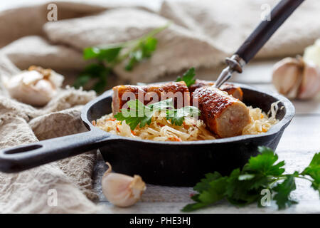 Padella con stufati di crauti e salsicce fritte. Foto Stock