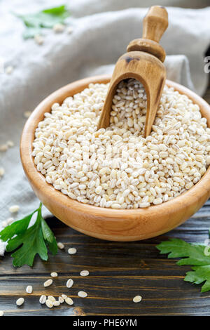 Cucchiaio di legno in una terrina a secco con il farro. Foto Stock