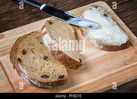 Fette di pane cosparse con burro di close-up sul tavolo Foto Stock