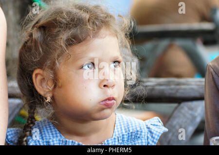 Bambina mangia con le sue guance piene Foto Stock