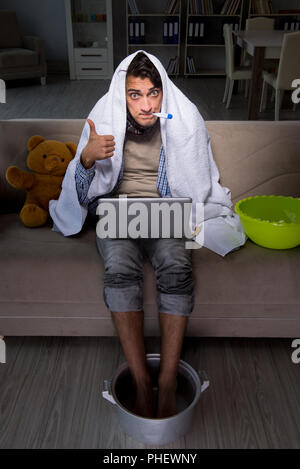 Uomo malato lavando i piedi a casa Foto Stock