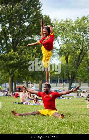 African giovane eseguendo acrobazie mostra di fronte al pubblico in Mount Royal Park, Montreal, Quebec, Canada Foto Stock