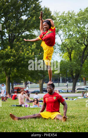 African giovane eseguendo acrobazie mostra di fronte al pubblico in Mount Royal Park, Montreal, Quebec, Canada Foto Stock
