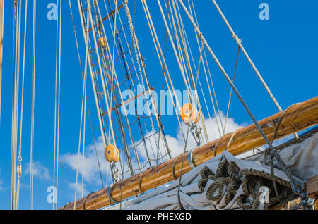 Vela ripiegata e montante su una vecchia barca a vela Foto Stock