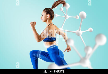 Sporty giovane donna corrono e saltando vicino a catena di molecola. Foto Stock