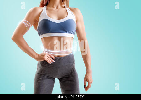 Giovane donna in abbigliamento sportivo ha dimostrato la sua forza muscolare del corpo atletico. Foto Stock