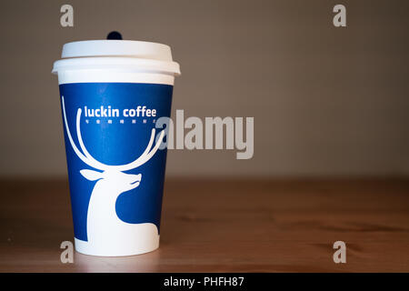 1 septembre 2018, Wuhan, Cina : una tazzina di caffè Luckin sul tavolo di legno sfondo Foto Stock
