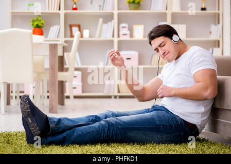 Giovane studente ascoltando la musica a casa Foto Stock