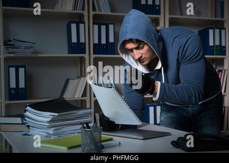 Giovane uomo in attività di spionaggio industriale concept Foto Stock