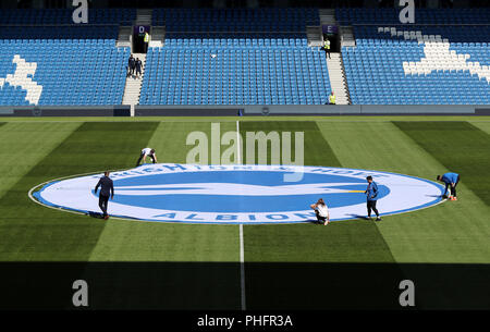 Brighton & Hove Albion giocatori sul campo come il personale, stendere il club crest sul cerchio centrale prima della Premier League al AMEX Stadium, Brighton. Foto Stock