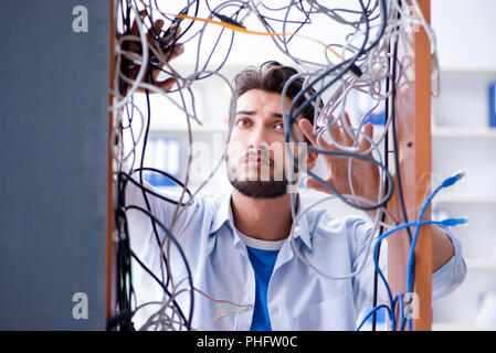 Computer repairman lavorando sulla riparazione della rete in workshop IT Foto Stock