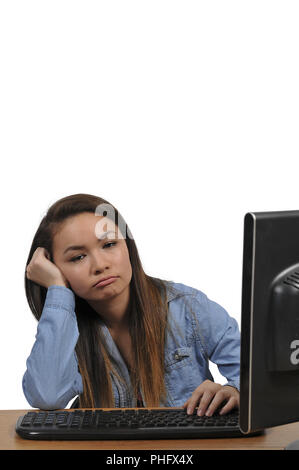 Ragazza adolescente facendo i compiti su un computer Foto Stock