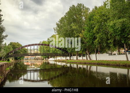 Ponte pedonale e la sua riflessione sul fiume Sertã, Sertã, Portogallo. Foto Stock