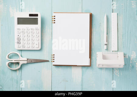 Moderno mock up laici piana del notebook e stationery in blu sullo sfondo di legno - Concetto di creativo dello spazio di lavoro Foto Stock