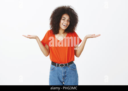 Piscina colpo di felice spensierato bella donna con acconciatura afro in eleganti vestiti, scrollare con diffusione palme e bel sorriso, essendo indifferente e chill, avente nessuna preoccupazione oltre il muro grigio Foto Stock