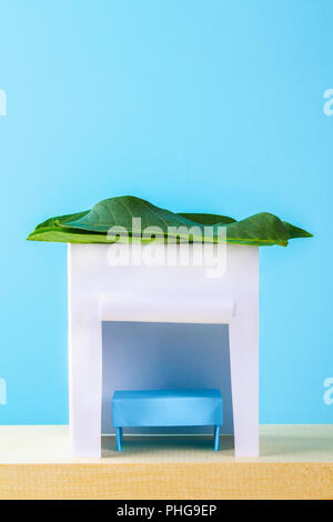 Felice Sukkot. Una capanna fatta di carta rivestito con foglie su uno sfondo blu. Copiare lo spazio Foto Stock