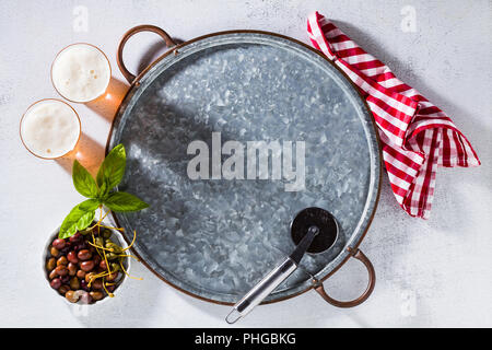 Svuotare vassoio metallico, bicchieri di birra e una pizza con il coltello sul tavolo. Banner per ristoranti, birrerie e pubblicità. Spazio libero per la scrittura di testo. copia Foto Stock