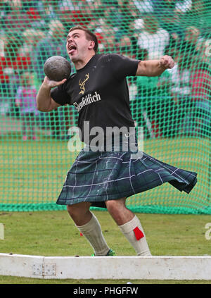 Heavyweight James Dawkins getta una pietra durante il Braemar Royal Highland Gathering al Princess Royal e il Duca di Fife Memorial Park, Braemar. Il raduno è stato eseguito nella sua forma attuale dal 1832. Foto Stock