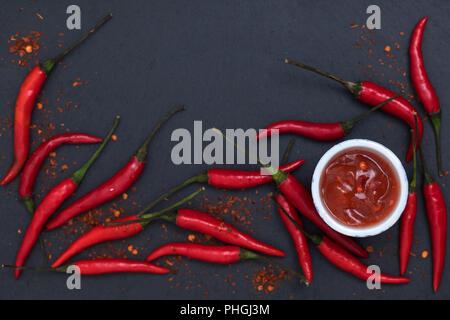 Peperoncino salsa con pasta fresca e incrinato pepe nero ardesia sfondo vista superiore Foto Stock