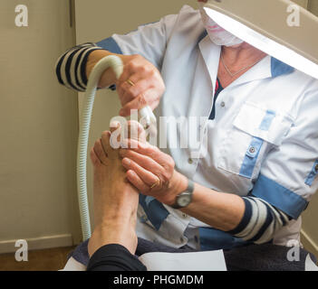 Pedicure femminile al lavoro con il piede Foto Stock