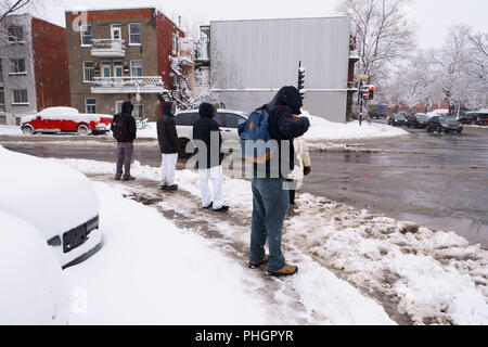 Montreal, Quebec / Canada - 1 Aprile 2018 : Le persone sono in attesa di attraversare la strada subito dopo una nevicata in città. Foto Stock