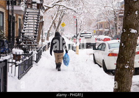 Montreal, Quebec / Canada - 1 Aprile 2018 : un uomo senza tetto è il prelievo di lattine vuote dopo una nevicata. Foto Stock