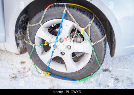 Al volante di una vettura con montate catene invernali Foto Stock