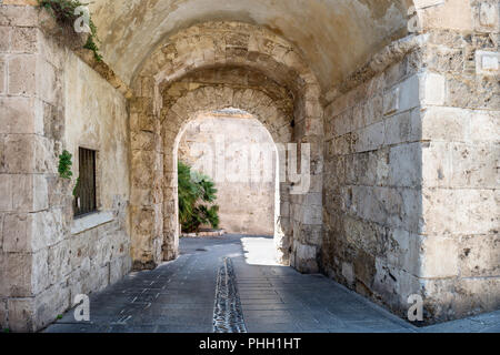 Antica pietra passaggio nel muro di pietra Foto Stock