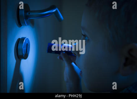 Curioso ragazzo con torcia Foto Stock