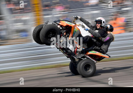 Hasenmoor, Germania. 01 Sep, 2018. 01.09.2018, Schleswig-Holstein, Hasenmoor : uno stunt mostra i suoi trucchi con il suo co-pilota su un quad in Hartenholm aeroporto. Un festival celebra la nuova edizione del leggendario "Werner gara' dal 1988 tra il proprietario del pub Henze e il fumetto artista Feldmann. Credito: Carsten Rehder, Frank Molter/dpa/Alamy Live News Foto Stock