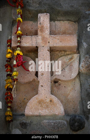 Una pietra scolpita cross incorporato nella facciata di un edificio in pietra a Santa Fe, New Mexico USA Foto Stock