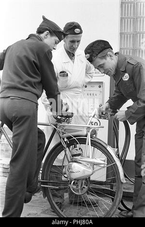 1950 Noleggio extra. Il ciclomotore tedesco e costruttore di motori Victoria fornisce questa bicicletta help motore chiamato Vicky. Esso può essere montato su qualsiasi biciclette ruota posteriore come un equipaggiamento supplementare. Esso ha 2 hp e due ingranaggi. Utilizzato quando non vi è alcuna tassa o la patente di guida necessaria. Quando l'acquisto di biciclette a motore e allo stesso tempo, il prezzo è di 690 Sek. Qui il giovane adolescente che riceve il gas serbatoio riempito in corrispondenza di una stazione di servizio Esso gas station. La Svezia degli anni cinquanta Foto Kristoffersson 1-1 Foto Stock