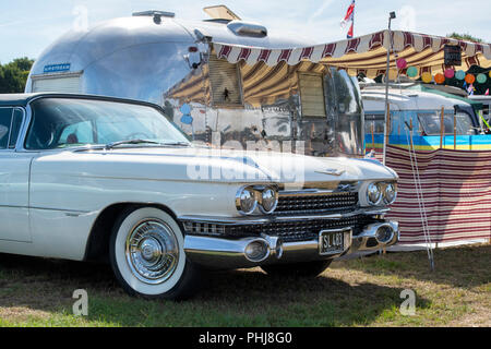 1959 Cadillac e una roulotte Airstream e a un vintage retrò festival. Regno Unito. Foto Stock